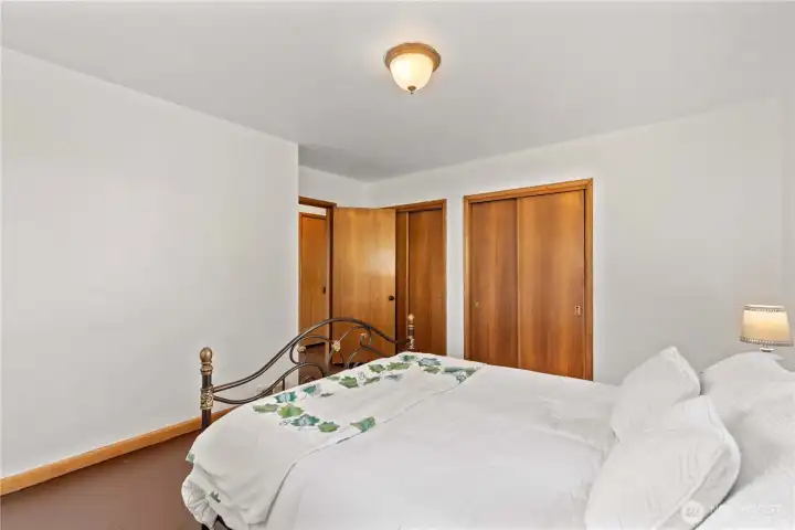 A comfortable and bright bedroom with rich wood trim and large closets, perfect for creating your own personal sanctuary.