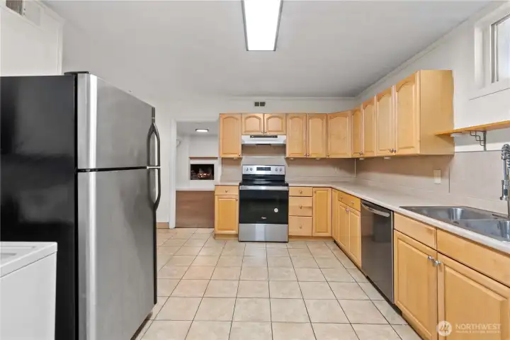 featuring light wood cabinetry, stainless steel appliances, and a spacious layout. Includes a double sink, electric cooktop, and tiled flooring—perfect for everyday cooking and entertaining.