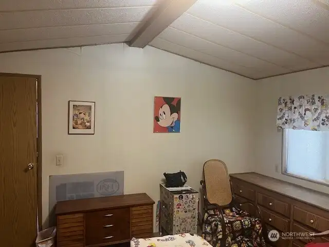 Primary bedroom with vaulted ceiling.