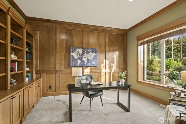 Second office on the main floor with gorgeous warm-tone woodwork and built-ins.