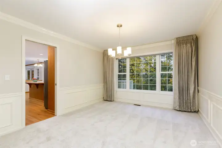 Formal dining room with all of windows overlooking the beautiful backyard trees and private lot.