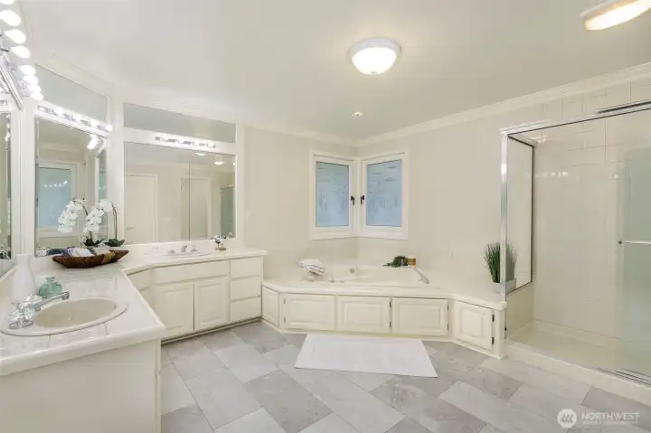 New tile floors in the five-piece primary bath complete with soaking tub and large walk-in shower.    Not shown in another large closet for linens.