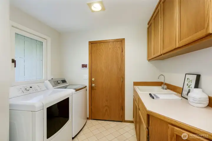 Utility room entry from the garage.   More storage here plus a deep utility sink and counter for folding clothes.    Note the beautiful windows throughout this home.