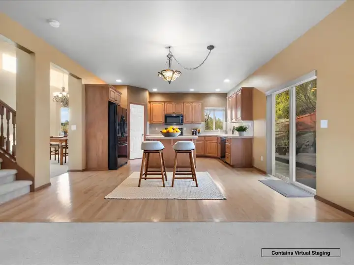 Open kitchen and dining area with island seating and easy access to the backyard deck