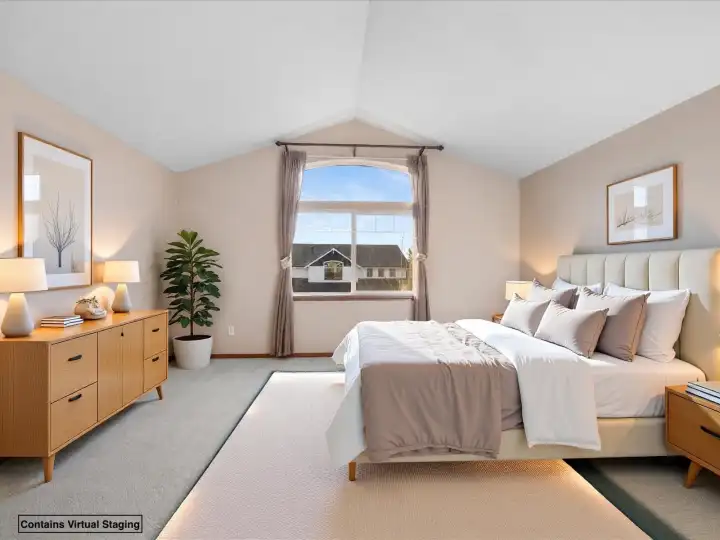Spacious primary suite with vaulted ceilings and a large arched window.