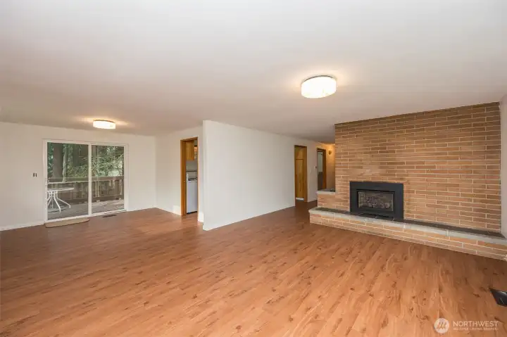 Open light filled living and dining room, gas fireplace, new luxury vinyl plank flooring over original hardwood floors.