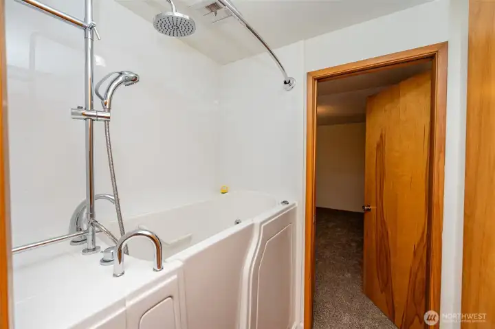 Hydrotherapy walk-in spa tub is between primary bedroom and main bathroom