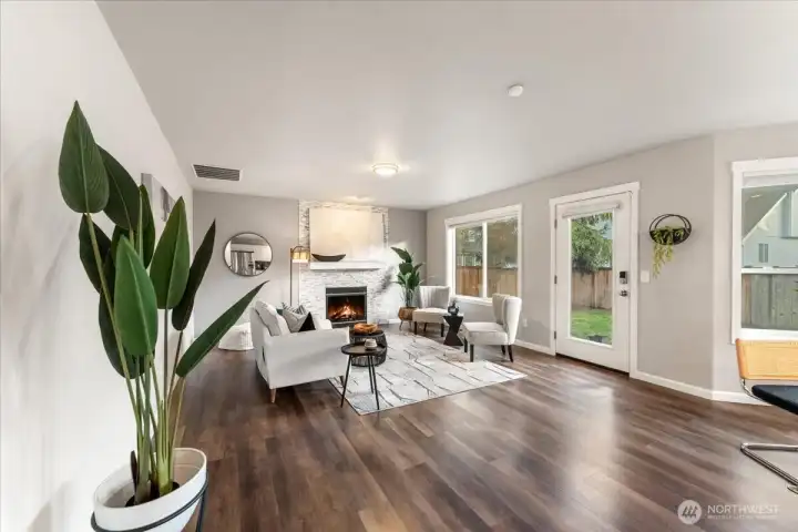 The family room features durable LVP hardwood flooring and a tiled, stone-front gas fireplace, creating a warm and inviting space for relaxing or gathering.