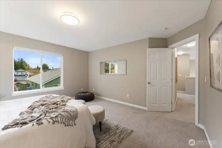 The primary bedroom is spacious and serene, featuring plush carpet that adds warmth and comfort.