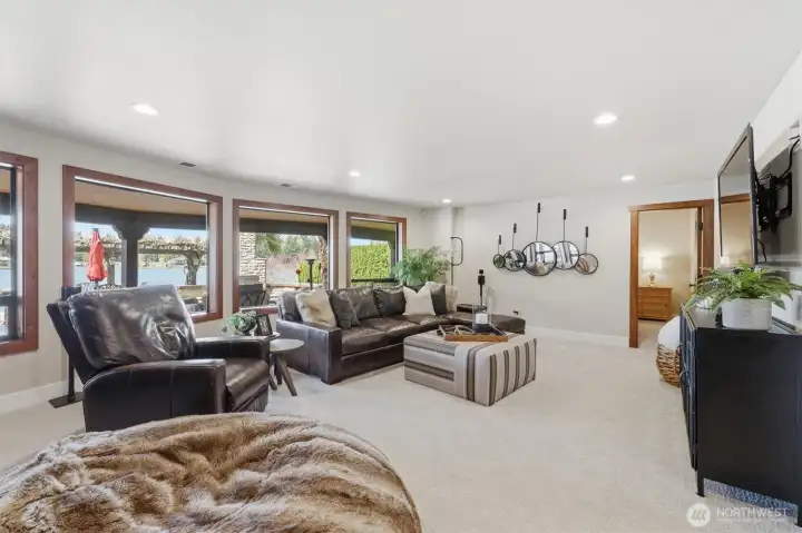 Spacious bonus room downstairs has large windows with views over the patio and out to the lake.