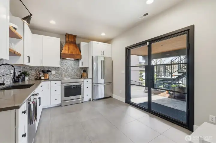 Kitchen has room for an extra table and double doors leading out to the patio.