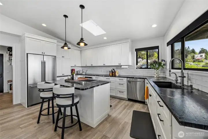 Main entry flows past laundry room into open concept kitchen-living room
