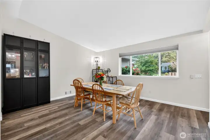 Bright and inviting dining space with large picture window, modern flooring, and plenty of room to gather.