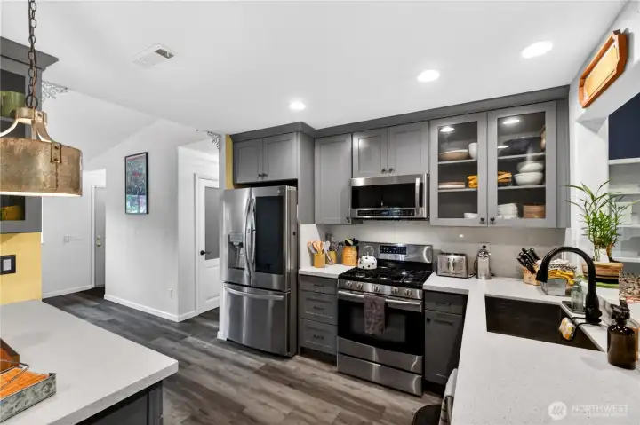 Sleek stainless steel appliances, elegant cabinetry, and clean quartz surfaces create a kitchen that’s as functional as it is beautiful.
