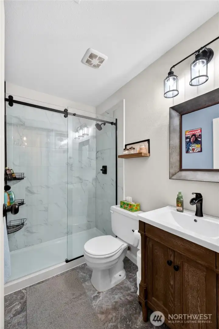 Beautifully remodeled bathroom featuring a sleek glass-enclosed shower, modern fixtures, and clean, timeless finishes.
