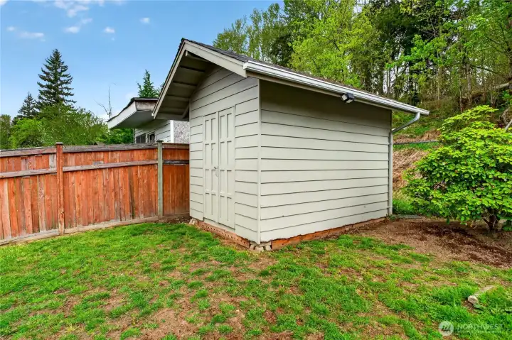 Convenient backyard storage shed provides extra space for tools, gear, and seasonal items.