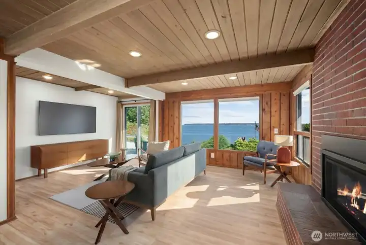 Staged Picture: Beautiful laminate wood flooring and a view of the mature landscaping and bay.