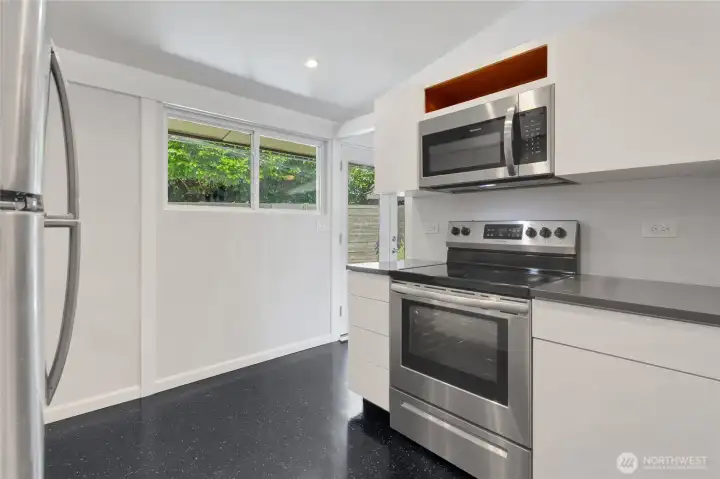 Kitchen with stainless, glass top stove.