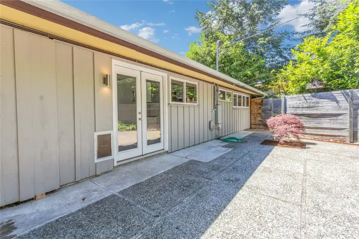 View of the backdoor in the "catio" area that comes with a large pet door next to the French doors leading into the living room.