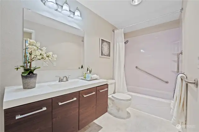 This is the renovated bathroom with ceramic tile flooring and room for additional storage.