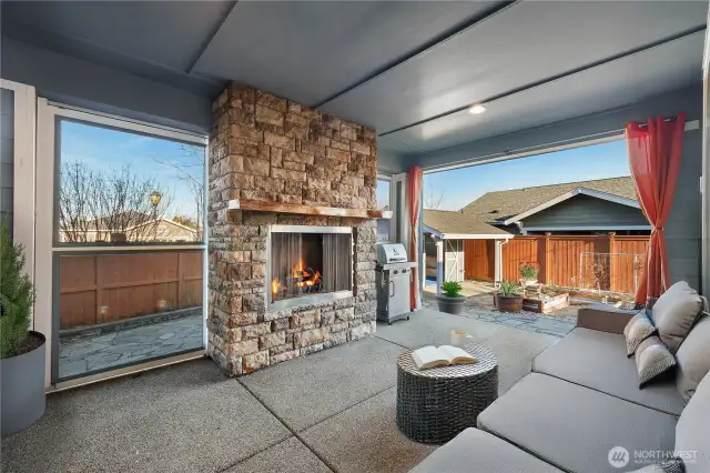 Large covered patio features outdoor fireplace and moveable screens for all seasons.