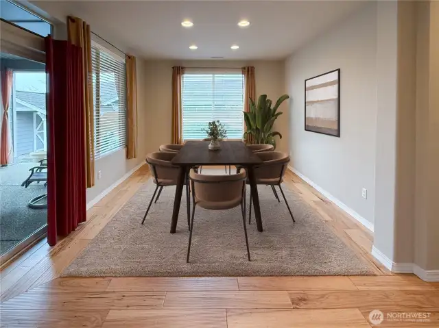 Large Dining area with an abundance of light. The doors lead to the backyard that features the covered patio, fireplace, shed, garden, and hot tub.