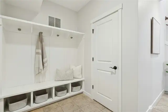 Lower level mudroom with built-ins and extra storage closet under the stairway