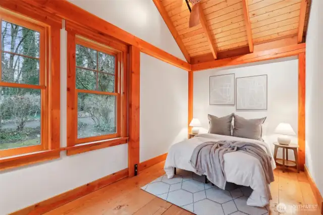 Second bedroom sports vaulted ceilings and large windows.