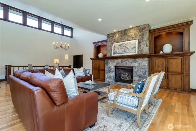 Gas fireplace with handsome stone hearth, flanked by custom built-ins.