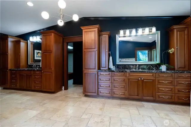 Primary en-suite with separate vanities & plentiful storage! The door between leads to two large walk-in closets.