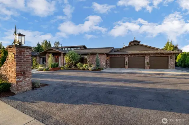 Four car garage, door on right has double parking with drive through rear garage door out to gravel drive that encircles the shop with three additional bays. 7 covered parking spaces in total!!