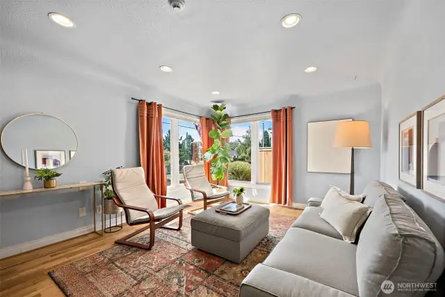 Living space with abundant natural light coming through corner picture windows.