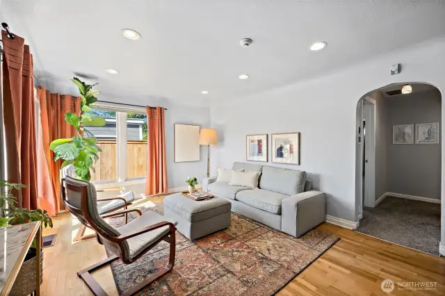 Living space with abundant natural light and curved hallway entrance.