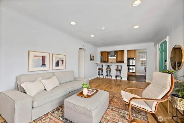 Living room space and bar eating area attached off kitchen opening.