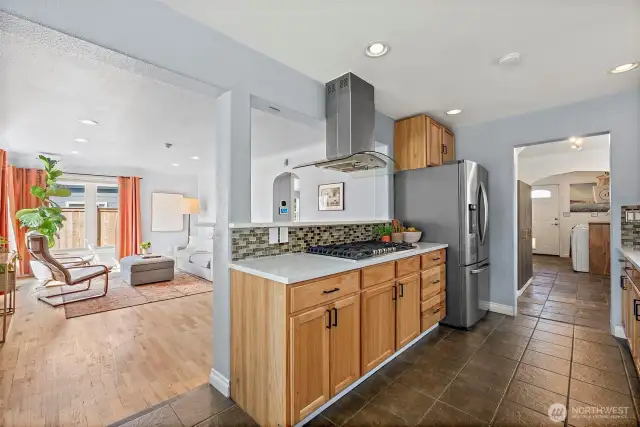 Galley Kitchen looking out into Living room space with utility room off other end.
