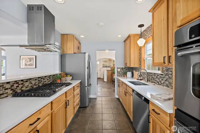 Galley Kitchen with matching appliance set. View from eating look into kitchen space with utility/mudroom at end.