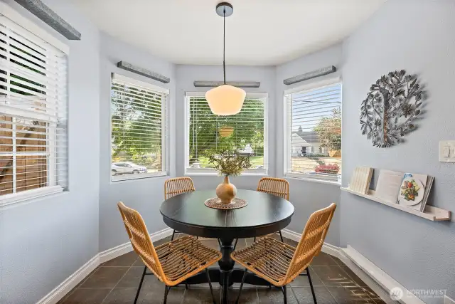 Eating nook off kitchen surrounded by windows bringing in tons of light
