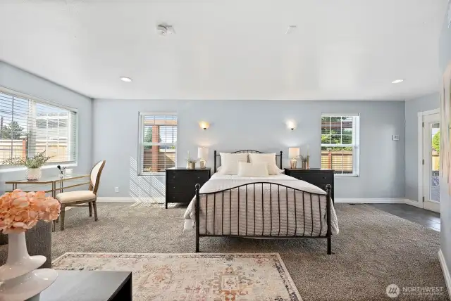 Generous primary bedroom suite full of natural light with multiple windows. Access to covered back deck through french doors in primary bedroom.