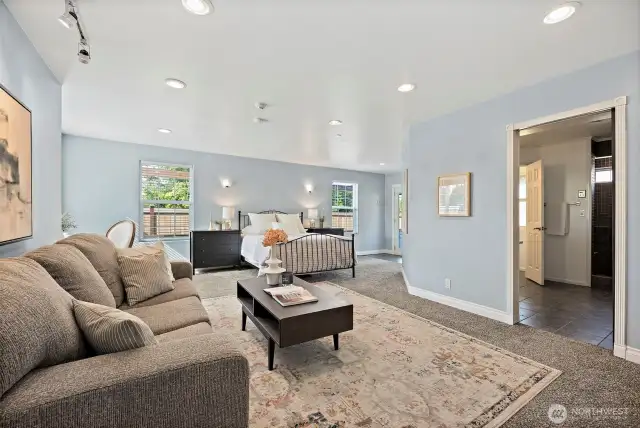 Enoromus primary bedroom with sitting space, en-suite bathroom, walk-in closet