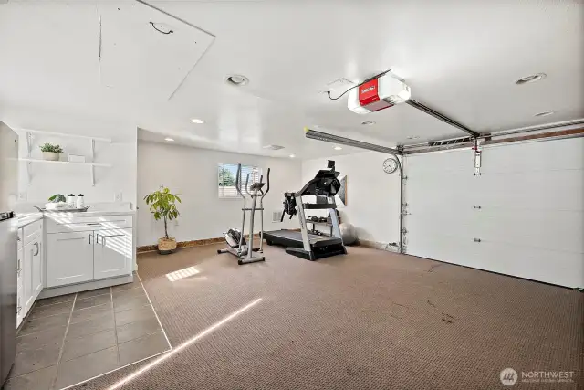 Interior of detached garage space currently setup for home gym with kitchenette and 1/2 bathroom. Possibilities for this space are endless! Open up for 2-car garage, or even convert to a DADU.