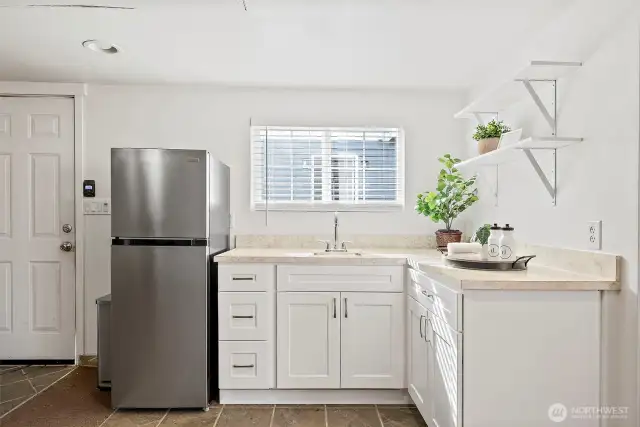 Kitchenette in detached garage brightened by natural light. Perfect spot for refreshments after a workout.