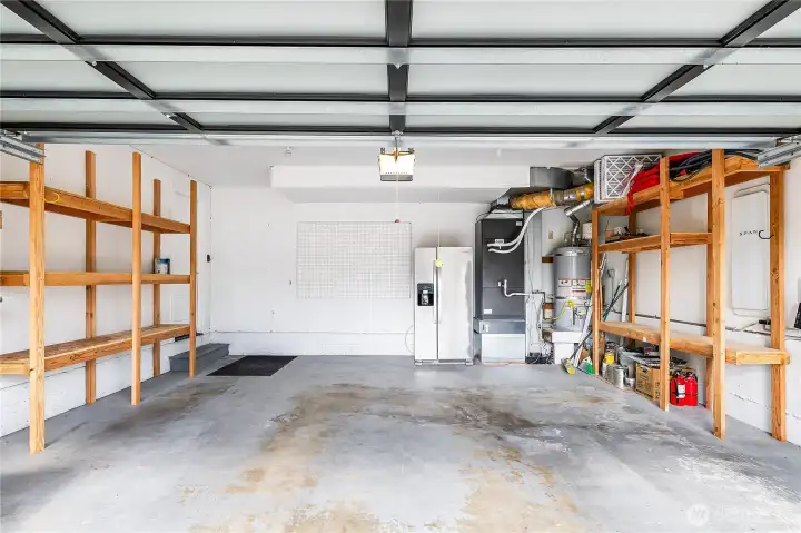 HUGE 2 car garage with built-in shelving for storage, included 2nd fridge, newer heat pump (2022) for central A/C & heat + Smart Electrical Panel with included hardwired EV Charger makes this a garage to be the envy of your friends.
