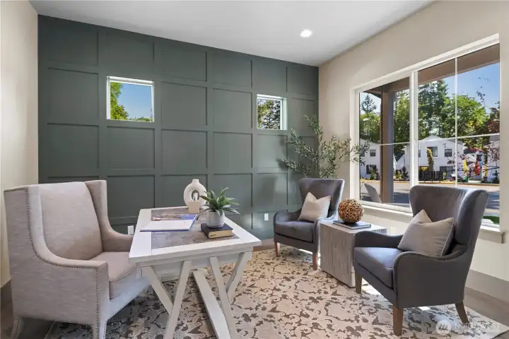 Large office with French door entry, box pattern millwork accent wall, and lovely view out to the evergreens in the distance.