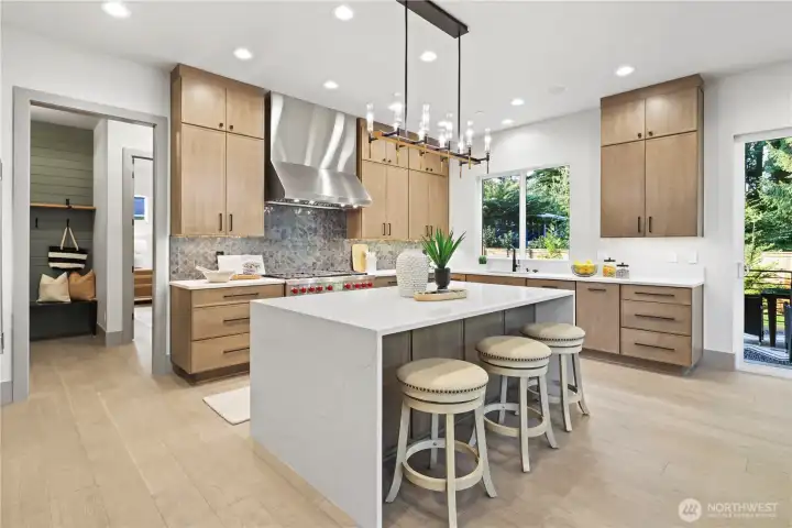 Warm wood-stained cabinets with loads of storage! Breakfast bar island slab quartz waterfall and seating for four, plus storage cabinets on the backside of the island.