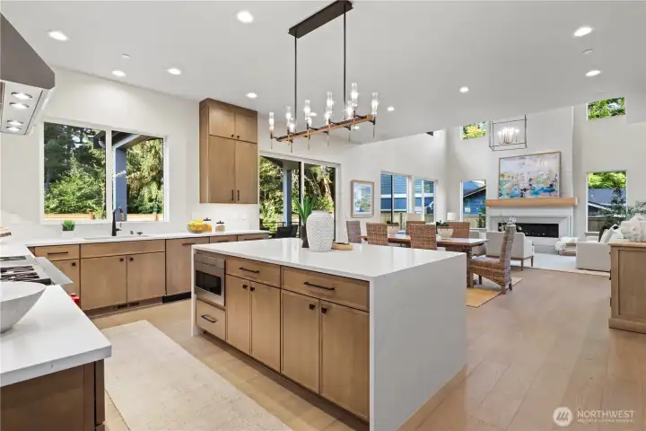 Chef's waterfall island, decorative chandelier, bar seating for 3-4, picturesque kitchen sink window looks out to the grassy backyard and neighboring Evergreens.