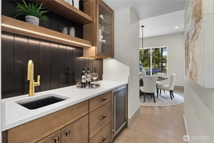 An entertainer’s dream wet bar: beverage chiller, bar sink, quartz counters, and abundant cabinetry to organize glassware, barware, and every mixing and serving essential.