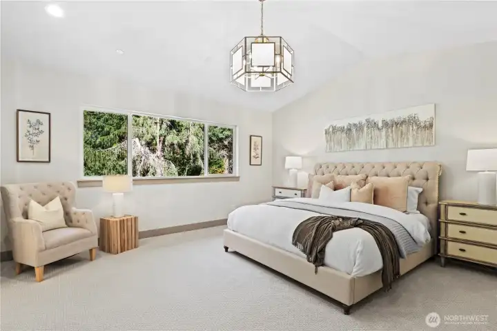Elegant primary bedroom with ceiling, chandelier, and serene Evergreen outlook.