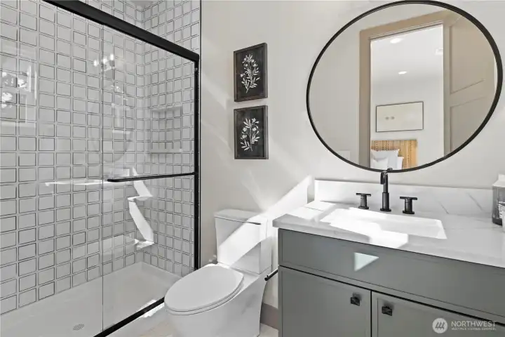 Upper level ensuite bathroom, single vanity sink, large step-in shower with recessed shampoo niche.