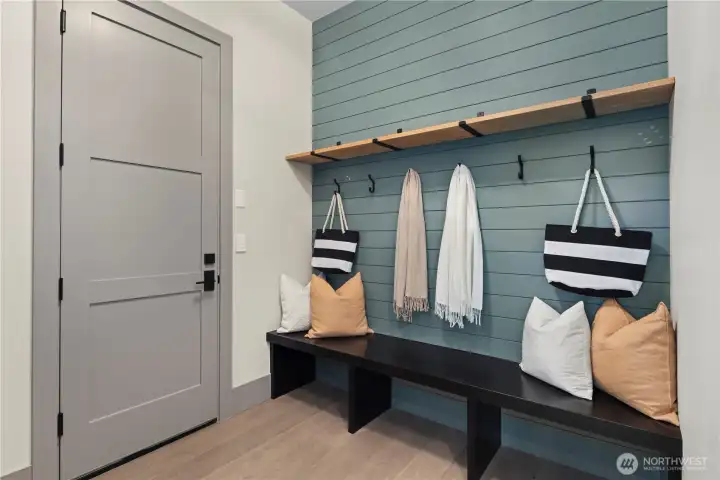 Functional mud room ready to drop bags, kick off shoes, and hang up coats. Utilize hooks on the shiplap wall or in the adjoining coat closet.