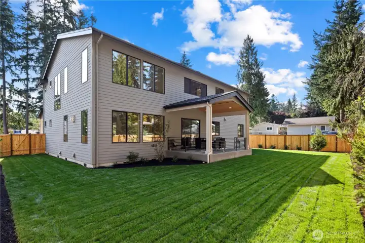 Glorious level backyard, sprawling lawn, covered patio, and fully-enclosed yard.